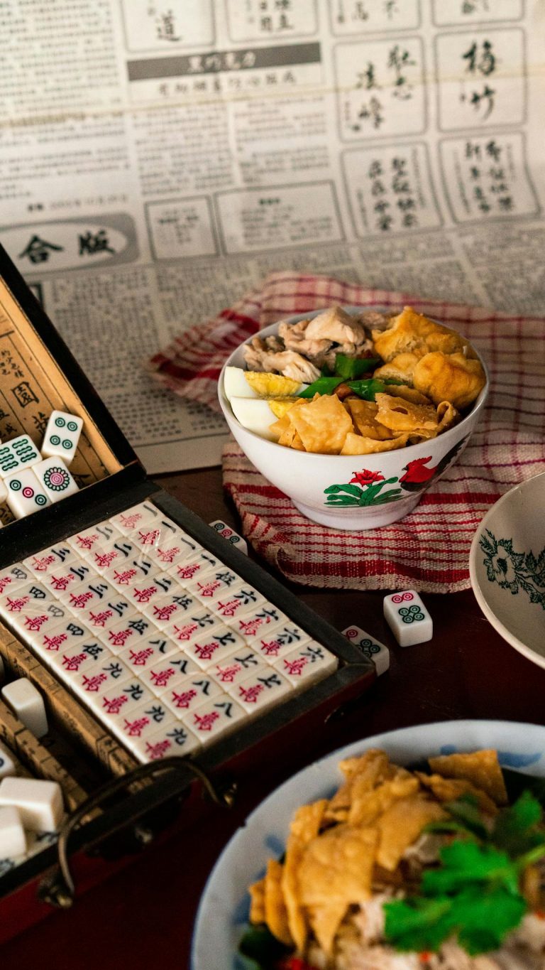 Authentic Asian dish alongside a Mahjong game set, evoking a cultural dining experience.