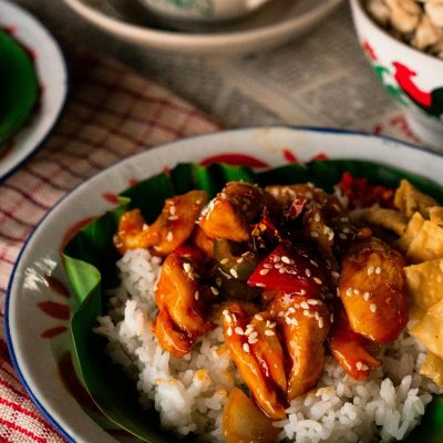 Delicious Asian chicken and rice dish garnished on a leaf, perfect for a flavorful meal.