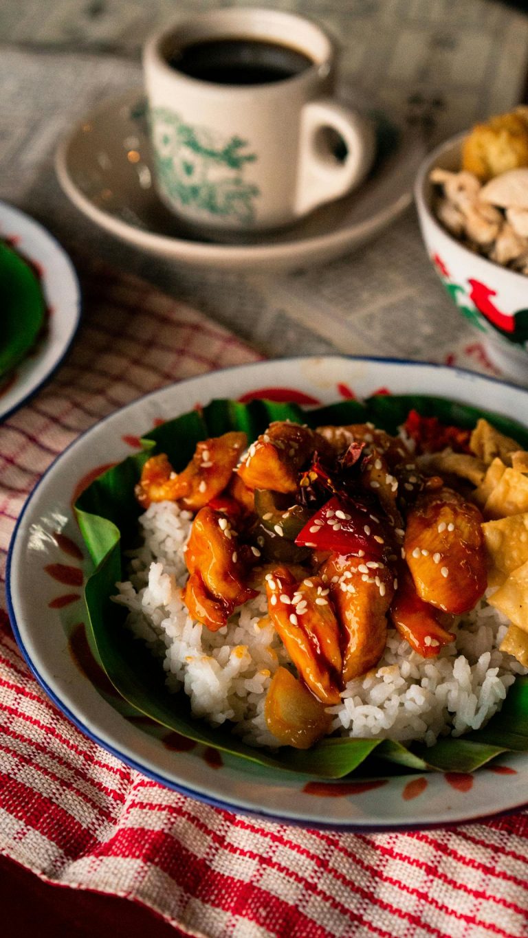 Delicious Asian chicken and rice dish garnished on a leaf, perfect for a flavorful meal.