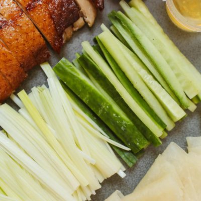 Delicious Peking duck served with fresh cucumber, spring onion, and savory sauces.