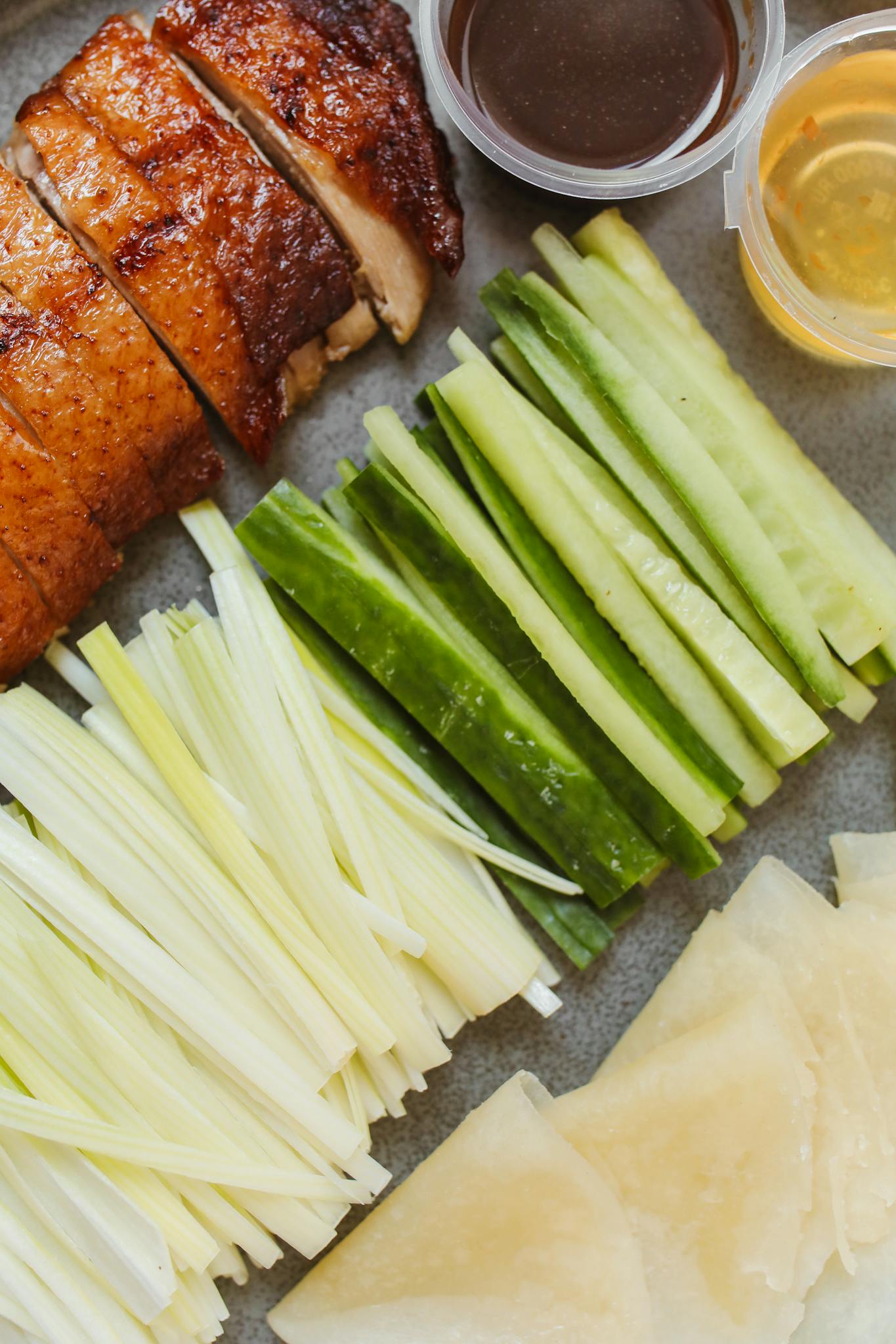 Delicious Peking duck served with fresh cucumber, spring onion, and savory sauces.
